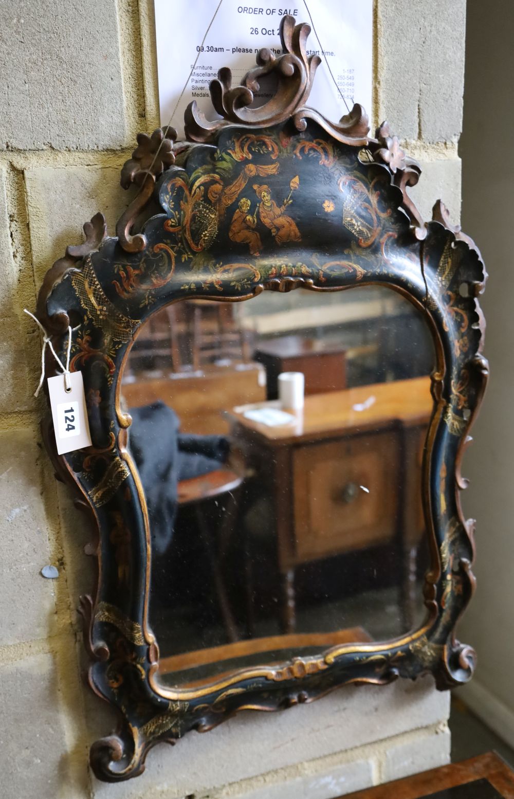 An 18th century style chinoiserie wall mirror, the cartouche shaped plated within cushioned decorated lacquer frame, width 46cm, height